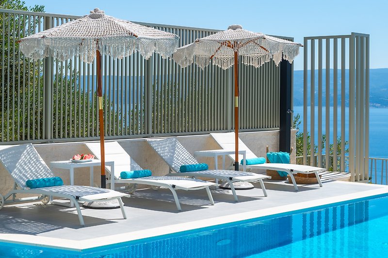 Luxuriöser Poolbereich mit Sonnenliegen und Meerblick!