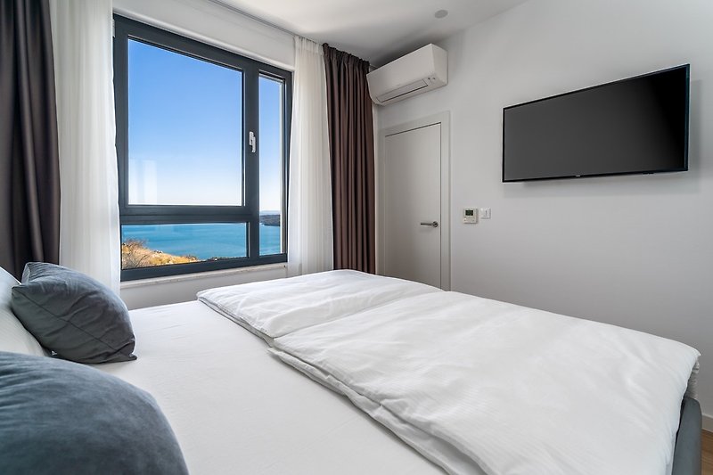 Bedroom No2 (North-East) with a king-size bed 180cmx 200cm, a TV, air-conditioning, and sea views.