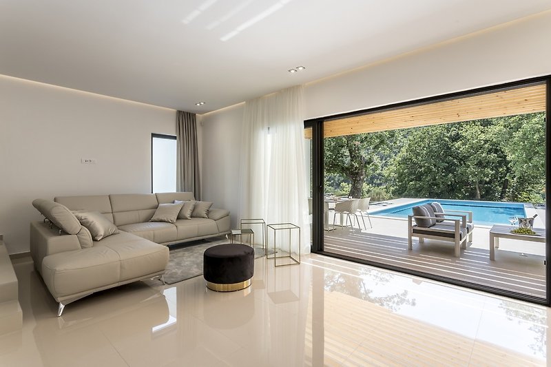 Glass walls with direct approach from the living room toward pool area