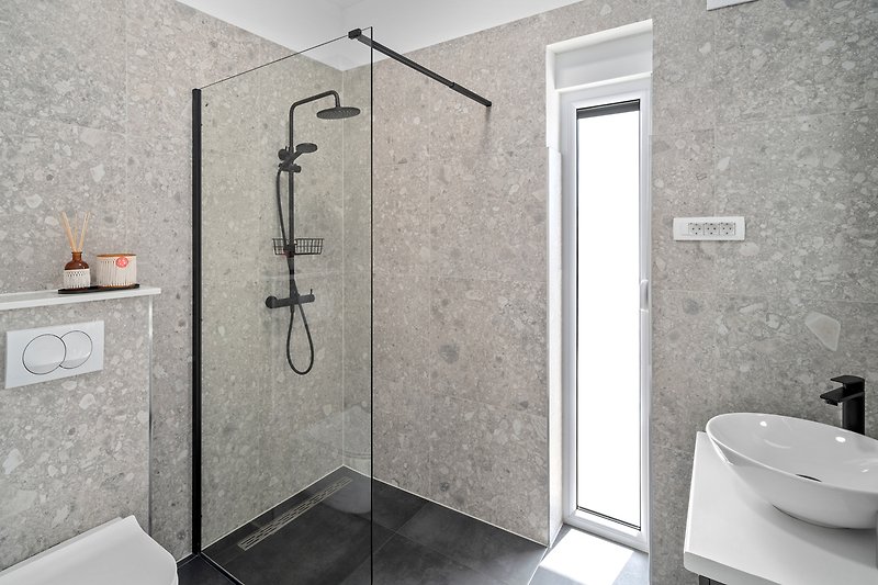 Dusche mit Glaswand, Metallarmatur, modernes Design.