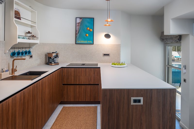 Moderne Küche mit Holzakzenten und stilvoller Beleuchtung.