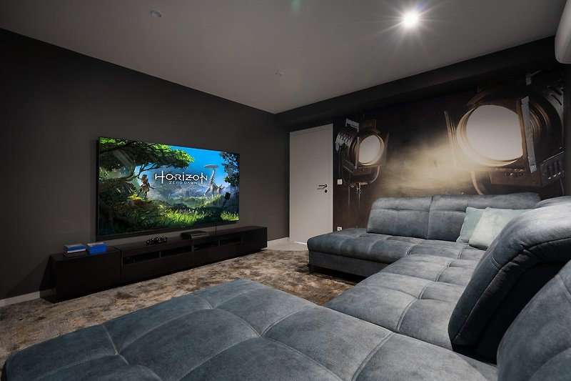 Play zone area with a sofa with a flat-screen TV with a PlayStation 4 for younger generations.