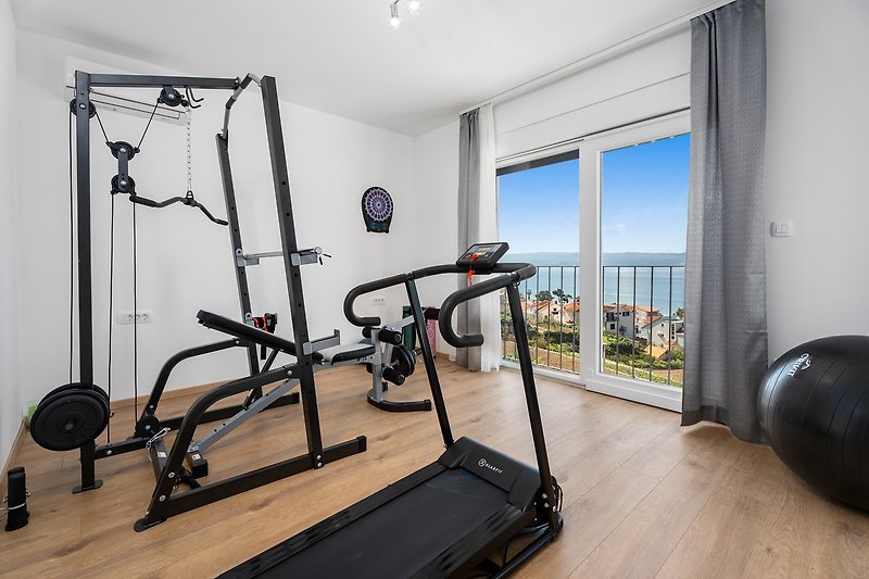 Gym with a treadmill, a multifunctional exercise machine, a yoga mat and pilates ball