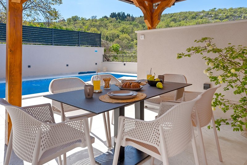 A covered outdoor dining area for 6 people for enjoying breakfast in a peaceful environment