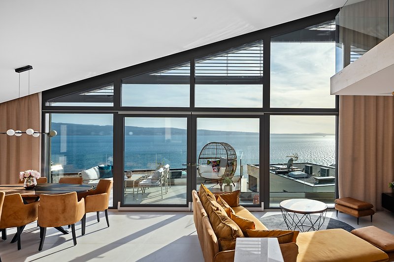 Large glass walls connect the villa's interior with the terrace with BBQ