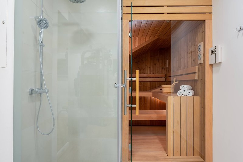 Sauna, Dusche, Fitnessraum und Fernseher in einem Raum im Erdgeschoss