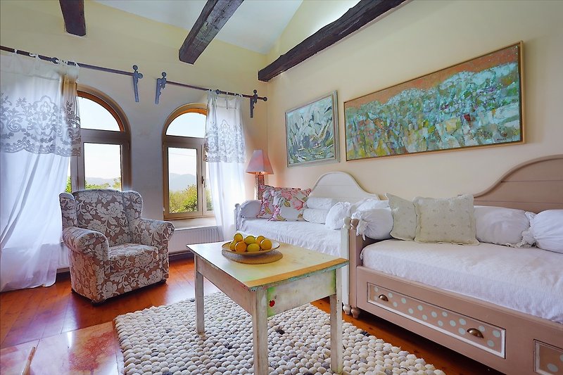 A Living room with two single beds (2 x 90 x 200cm), TV,  free WiFi, and an antique fireplace