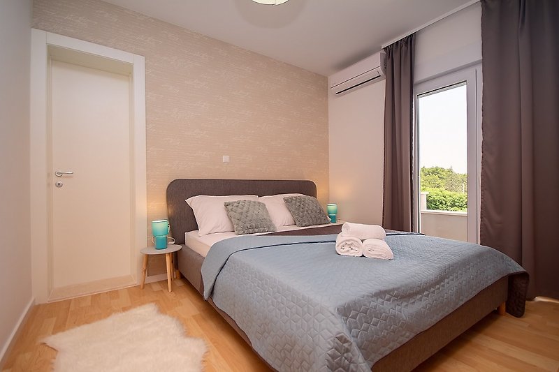 Schlafzimmer mit Doppelbett 160x200cm und en-suite Badezimmer und Ausgang zur Terrasse
