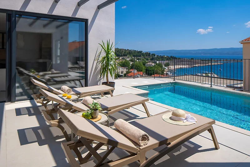 Ferienvilla mit Pool und Lounge im Außenbereich.