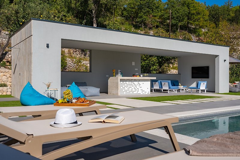 Few steps lead you to the terrace with a covered outdoor dining area for 14 people
