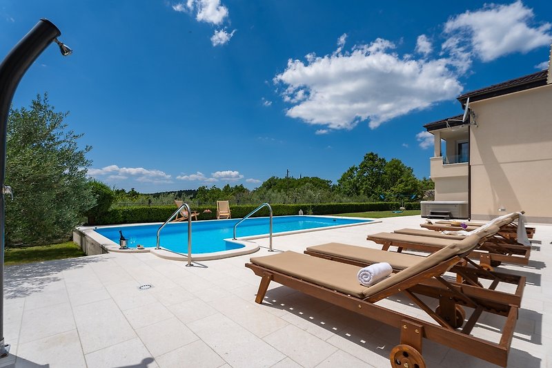 Stunning poolside view with a beautiful landscape and outdoor furniture.