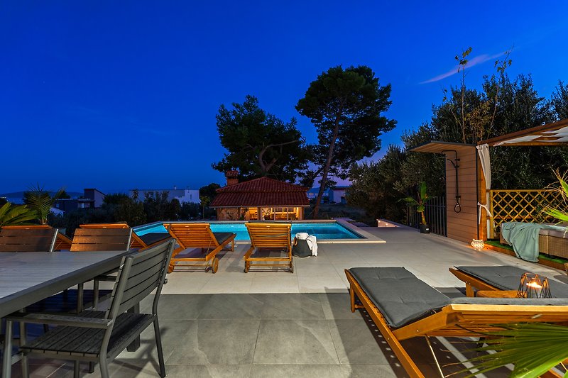 A poolside oasis with comfortable furniture, and a beautiful view