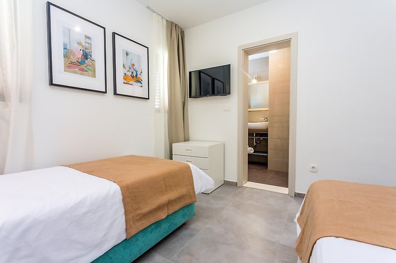 Schlafzimmer Nr. 3 mit 2 Einzelbetten (90 x 200 cm), Klimaanlage, Fernseher und eigenem Bad mit Dusche.