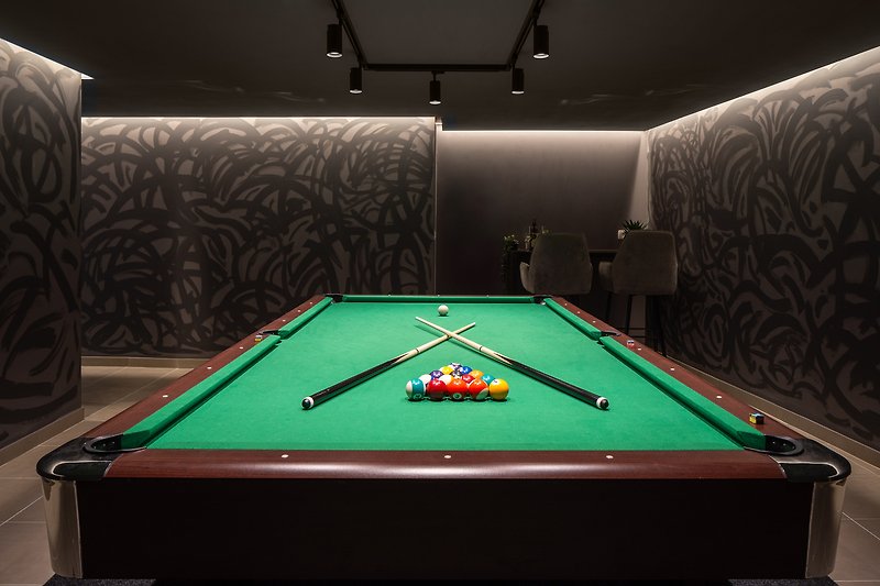 Enjoy this stunning billiard room with elegant furniture, perfect for recreation and indoor games
