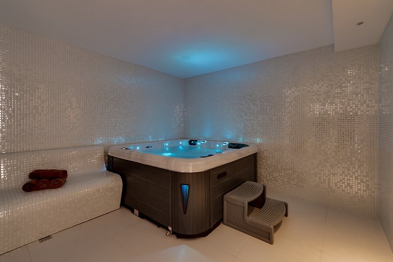 Luxurious spa area with steam room, shower, and whirlpool