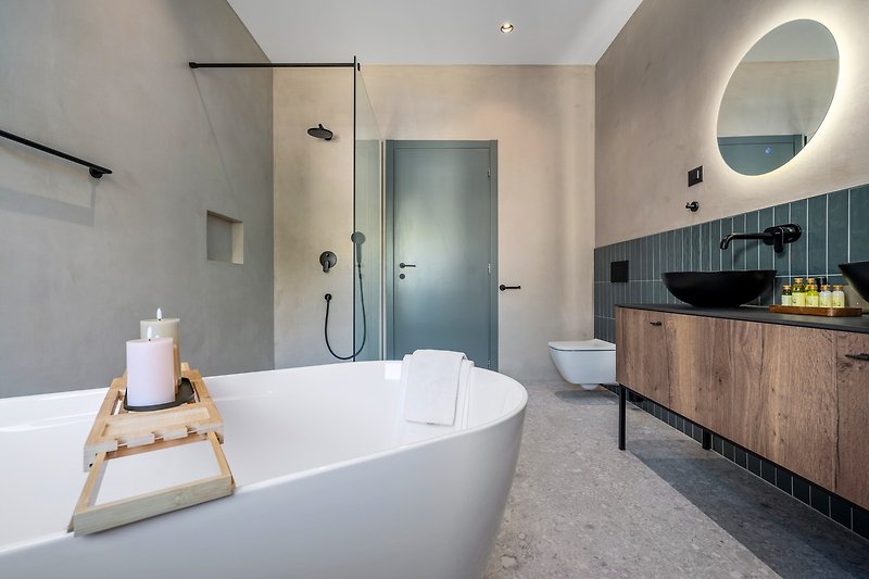En-suite bathroom with a self-standing bathtub and a shower, a double sink, a toilet