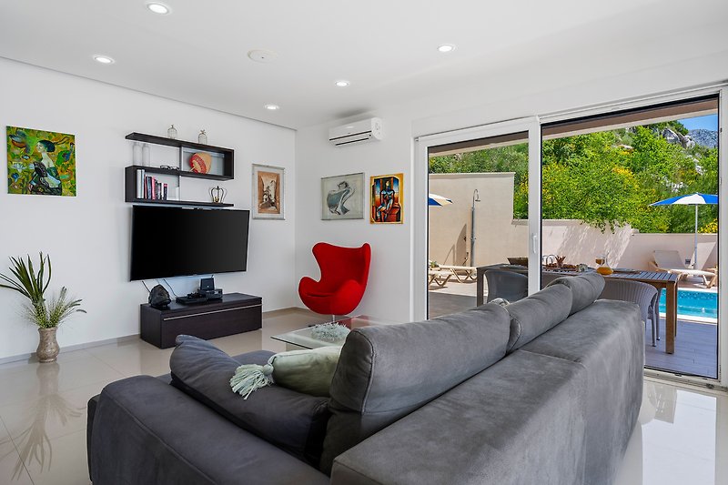 Das Wohnzimmer bietet ein bequemes Sofa mit einem Flachbildfernseher, einer PlayStation 4 und mehr.