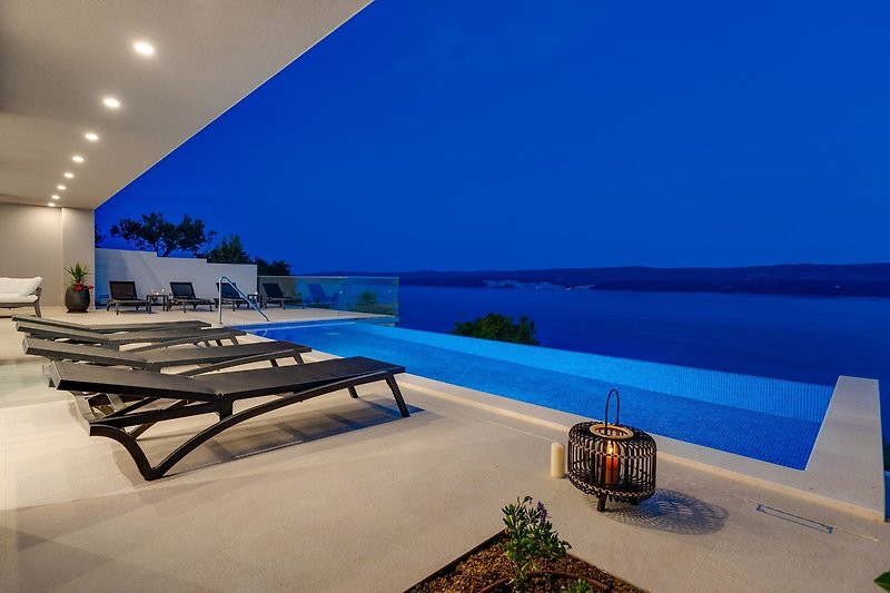 Eine Terrasse mit herrlichem Meerblick und Liegestühlen für 10 Personen.