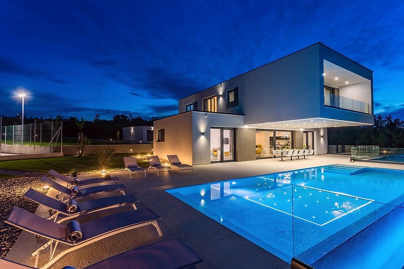Luxurious villa with a stunning pool, beautiful landscape, and modern interior design.