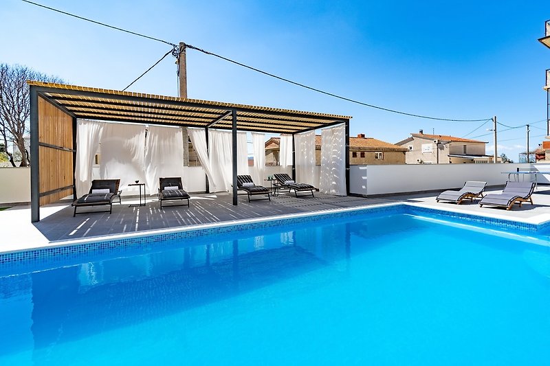 Die Villa bietet einen beheizten Pool mit Hydromassage, 4 Schlafzimmer mit eigenem Bad, eine Sommerküche, einen Sonnendeckbereich und eine P