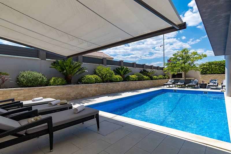Private, heated 8x4m pool with 8 comfortable lounge chairs and outdoor furniture
