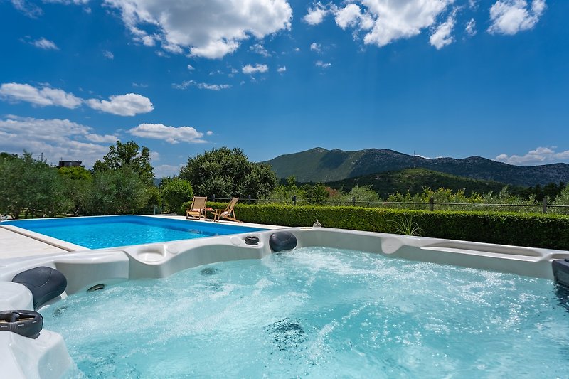 Stunning property with a pool, surrounded by nature and a beautiful blue sky.