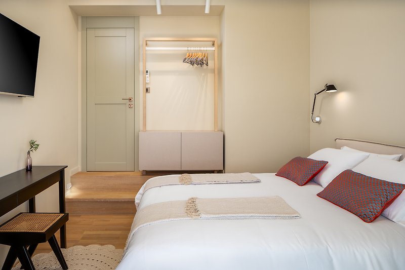 Stilvolles Schlafzimmer mit Holzmöbeln und gemütlicher Bettwäsche. Gemütliche Fensterdekoration.