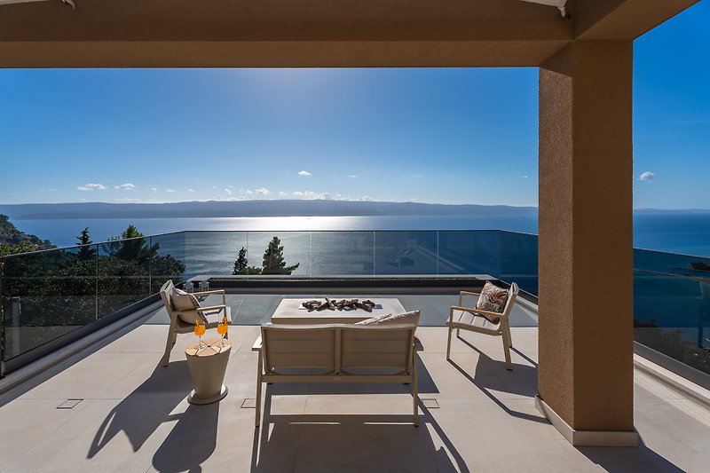 A stunning waterfront view with a stylish balcony and comfortable seating.
