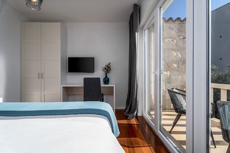 Bedroom No1 with a balcony with two chairs, sea and pool views