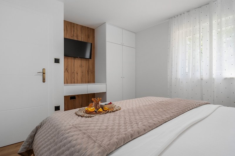 Schlafzimmer Nr. 2 (13,3 m2) mit einem Doppelbett 180 cm x 200 cm, Klimaanlage, einem Fernseher und Blick auf die Natur