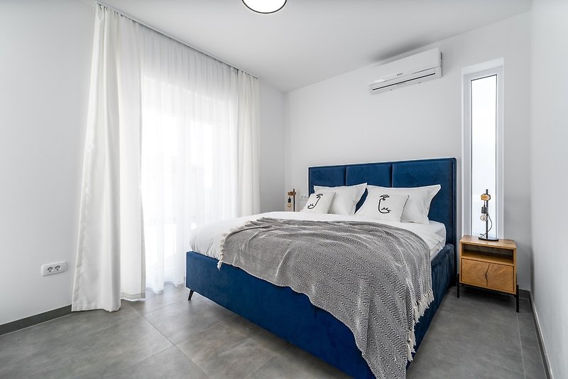 Ein Schlafzimmer Nr. 1 befindet sich im Erdgeschoss mit Kingsize-Bett, TV, Klimaanlage