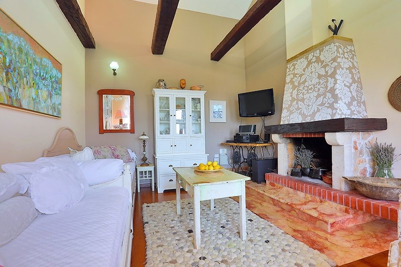 Ein Wohnzimmer mit zwei Einzelbetten (2 x 90 x 200 cm), TV, kostenlosem WLAN und einem antiken Kamin