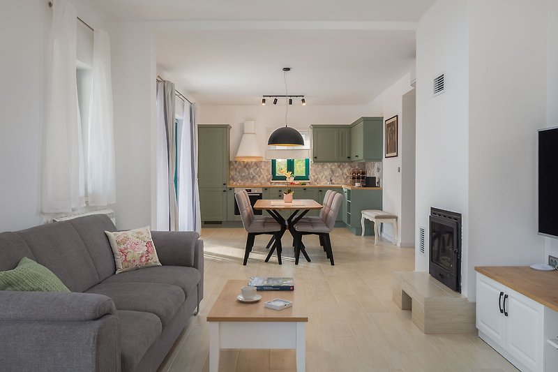Wohnzimmer mit Kamin, ein Sofa, einen Flachbildfernseher, Klimaanlage, kostenloses WLAN und Netflix