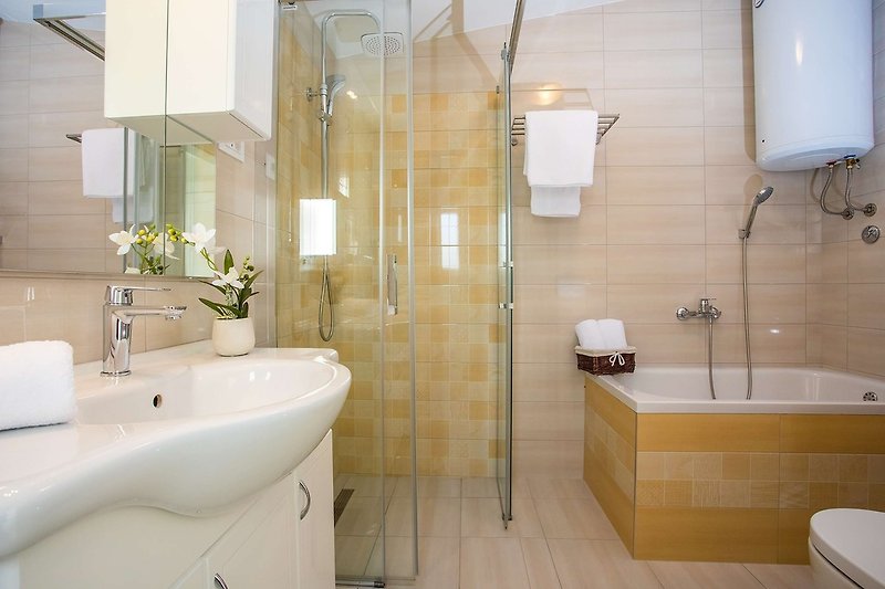 Familienbadezimmer mit Badewanne, Dusche, Bidet, WC und Waschmaschine.