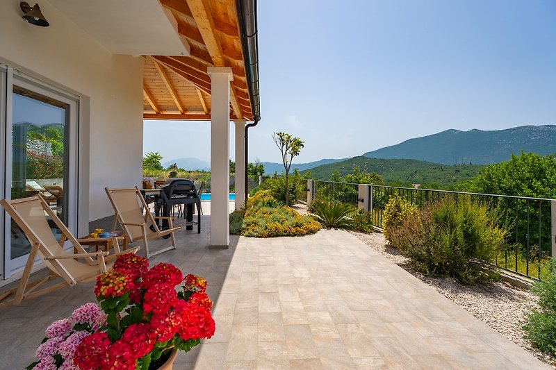The outdoor sitting area is next to the pool, with an amazing mountain view.