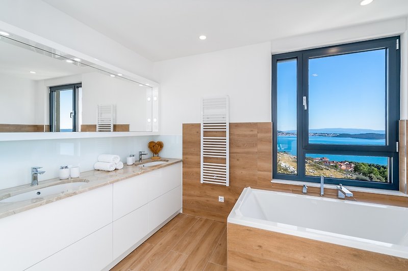En-suite Bathroom with a double sink, a shower, and a bathtub with sea views.