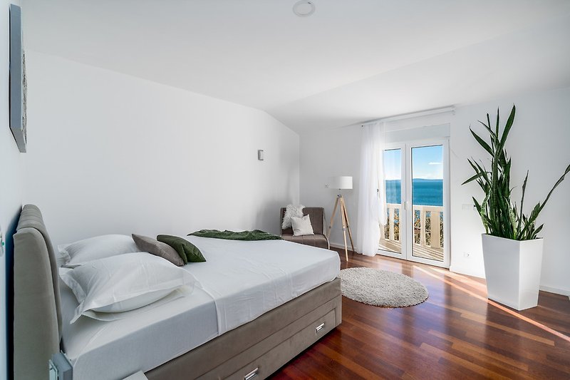 Schlafzimmer Nr. 3 mit einem Kingsize-Bett, einem Sofa für 1 Person und einem Balkon mit Meerblick