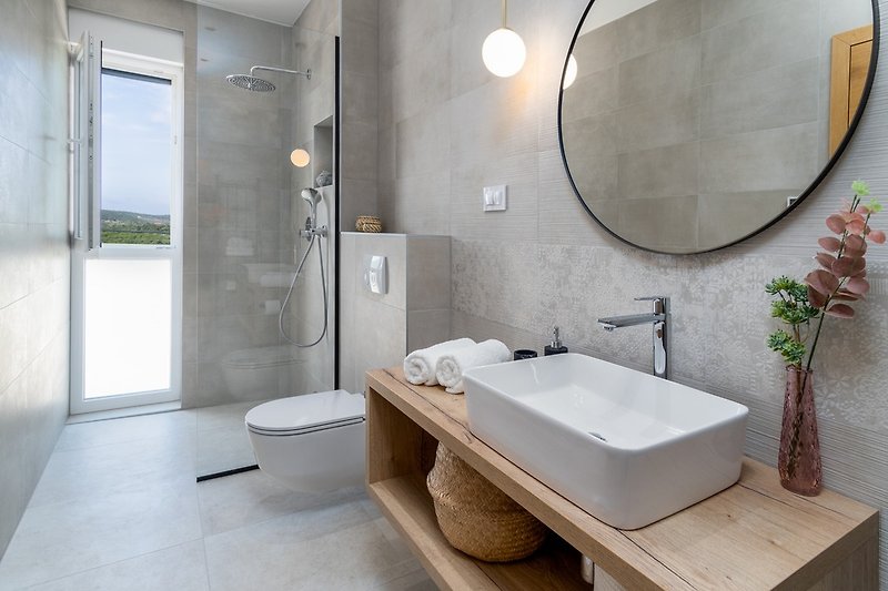 An en-suite bathroom with a shower, a sink, and a toilet