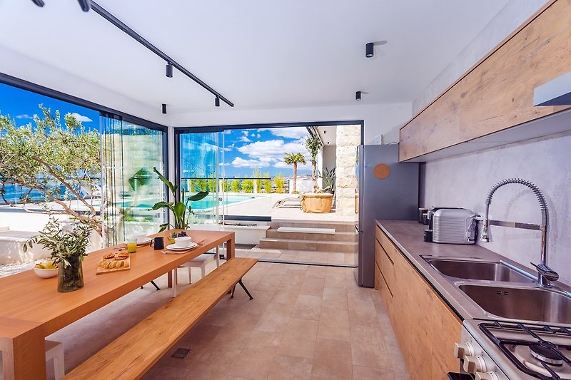 A fully equipped summer kitchen with BBQ is next to the pool area