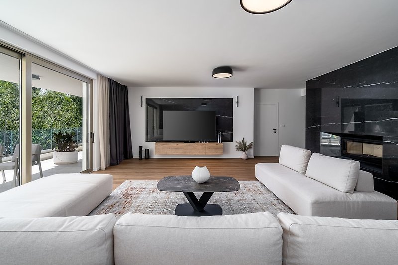 geräumiges Wohnzimmer 63 m2 nach Süden ausgerichtet mit bequemen und stilvollen Sofas, einem riesigen Flachbildfernseher, einer Play Station