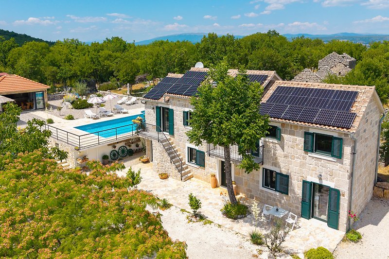 Villa mit Pool und einladender Gartenlandschaft.