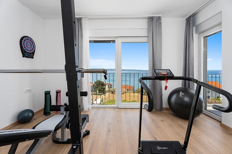 Gym with a TV, A/C, and a balcony