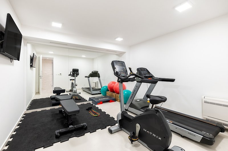 At this level is also a Gym with a treadmill, an exercise bike, weights, a bench, pilates balls, and a TV