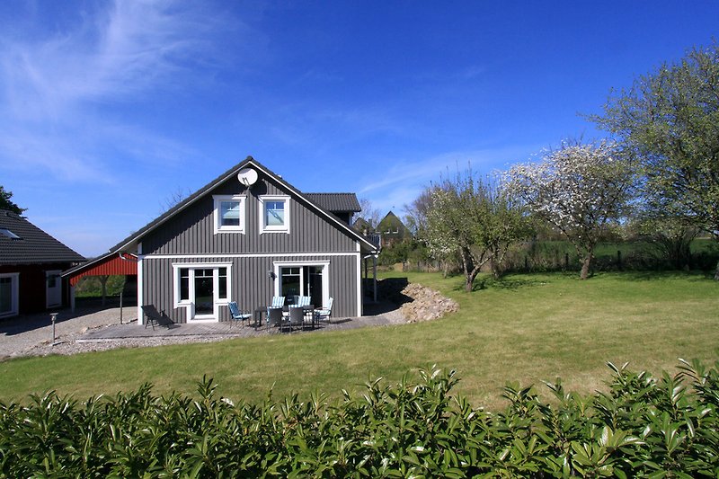 Skandinavisches Haus mit Garten, Strandkörben und Gartenmöbeln