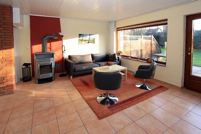 Wohnzimmer mit SAT-TV, Kamin und Terrassentür
