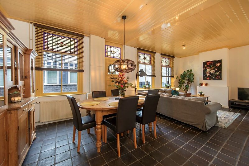 Stilvolles Wohnzimmer mit Holzmöbeln, Tisch, Stuhl und Pflanze.