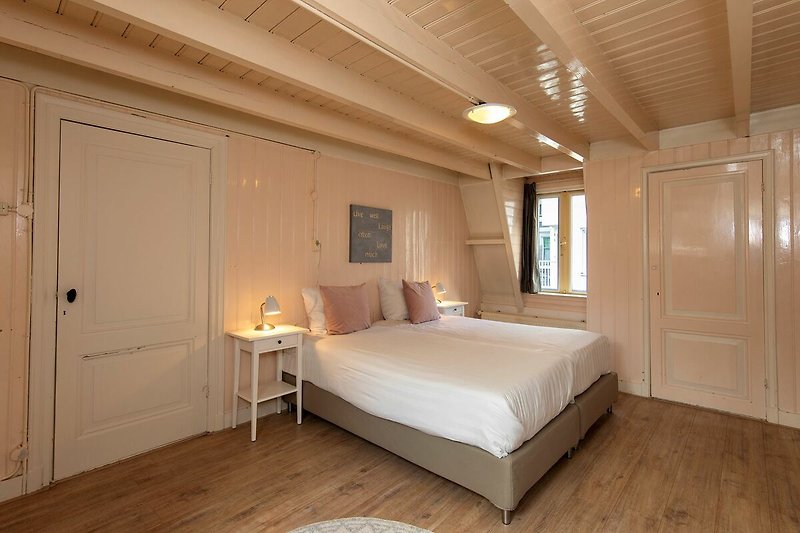 Modernes Schlafzimmer mit Holzmöbeln, gemütlichem Bett und stilvoller Beleuchtung.
