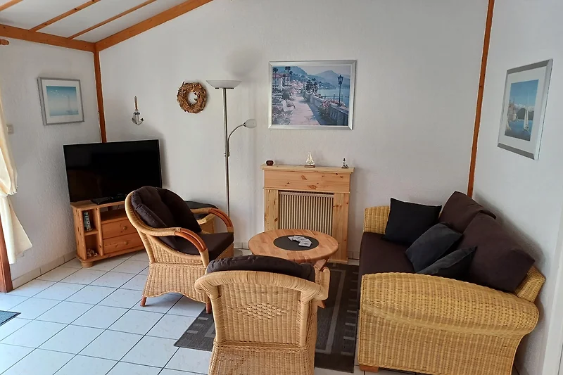 Wohnzimmer mit Holzmöbeln, Sessel und Kaffeetisch.