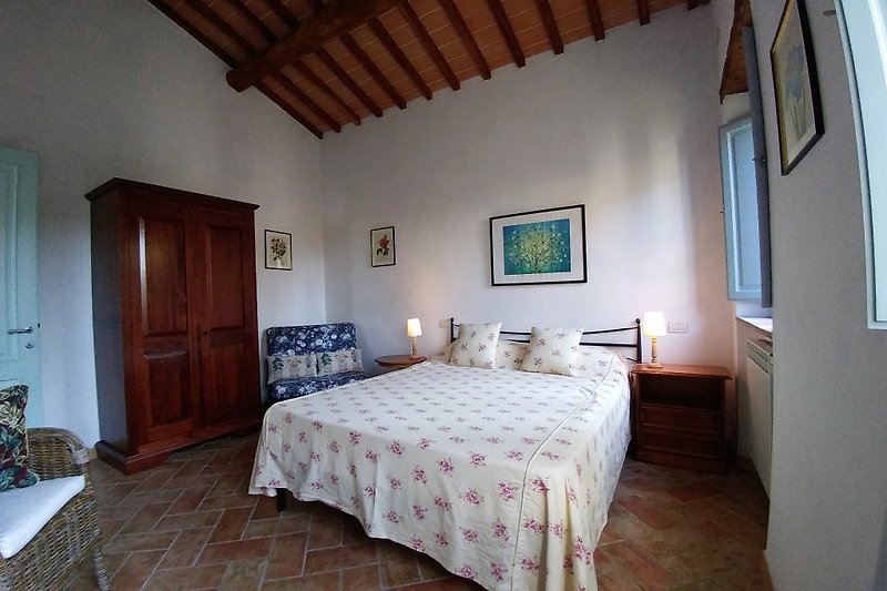 Schlafzimmer mit warmen Kastanienholzbalken und handgefertigten Deckenplatten