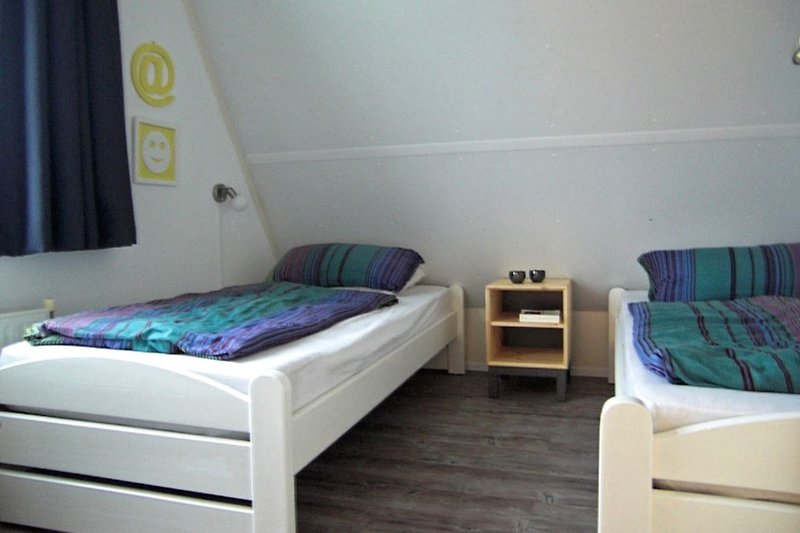 Bedroom with 2 single beds on the upper floor.